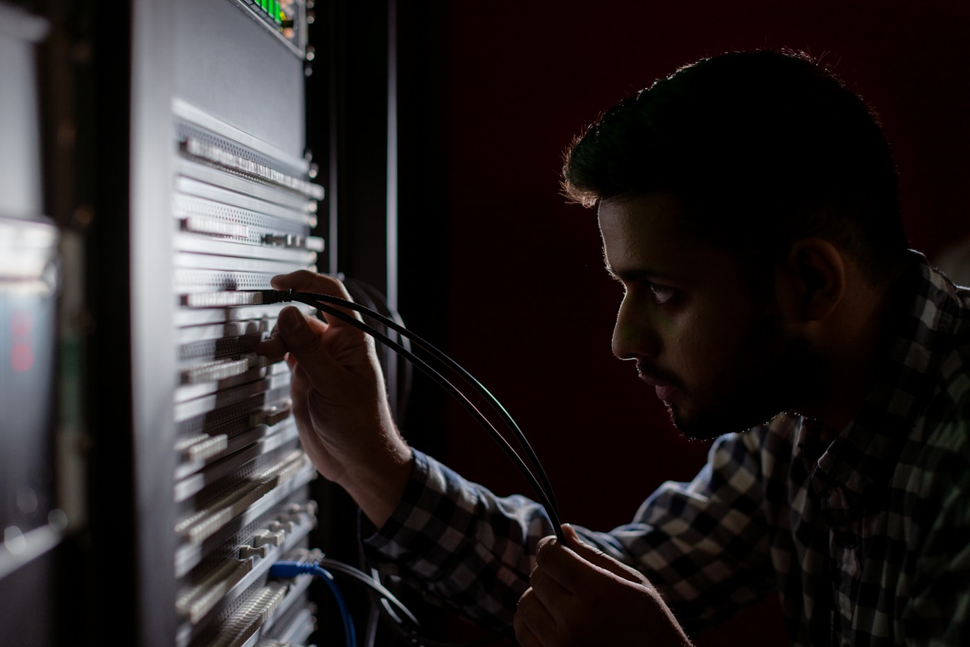 Nätverkstekniker som kopplar kablar i ett serverrack